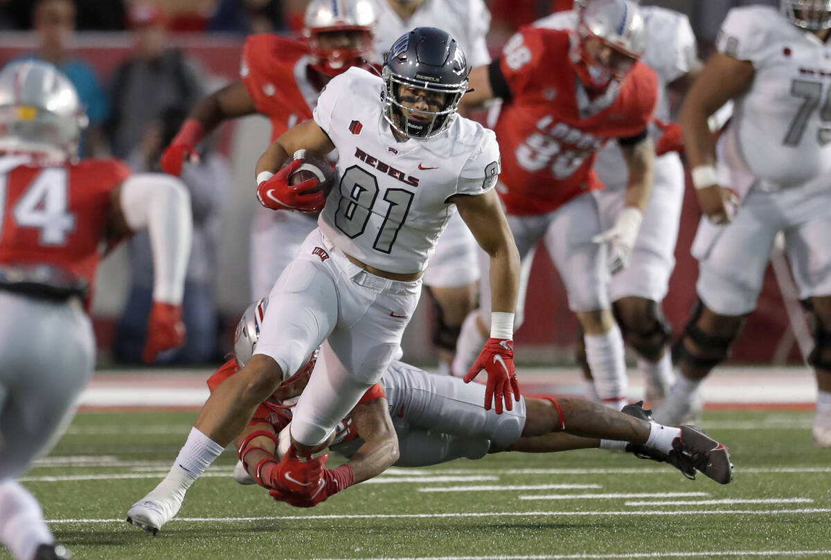 UNLV tight end Kue Olotoa (81) breaks a tackle attempt by New Mexico safety Tavian Combs during ...
