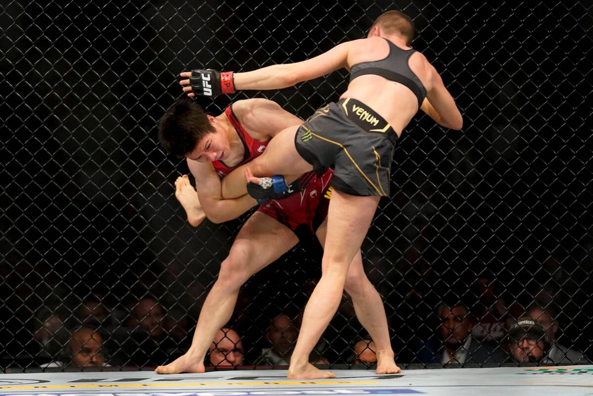 Weili Zhang tries to take down Rose Namajunas during a straw weight mixed martial arts champion ...