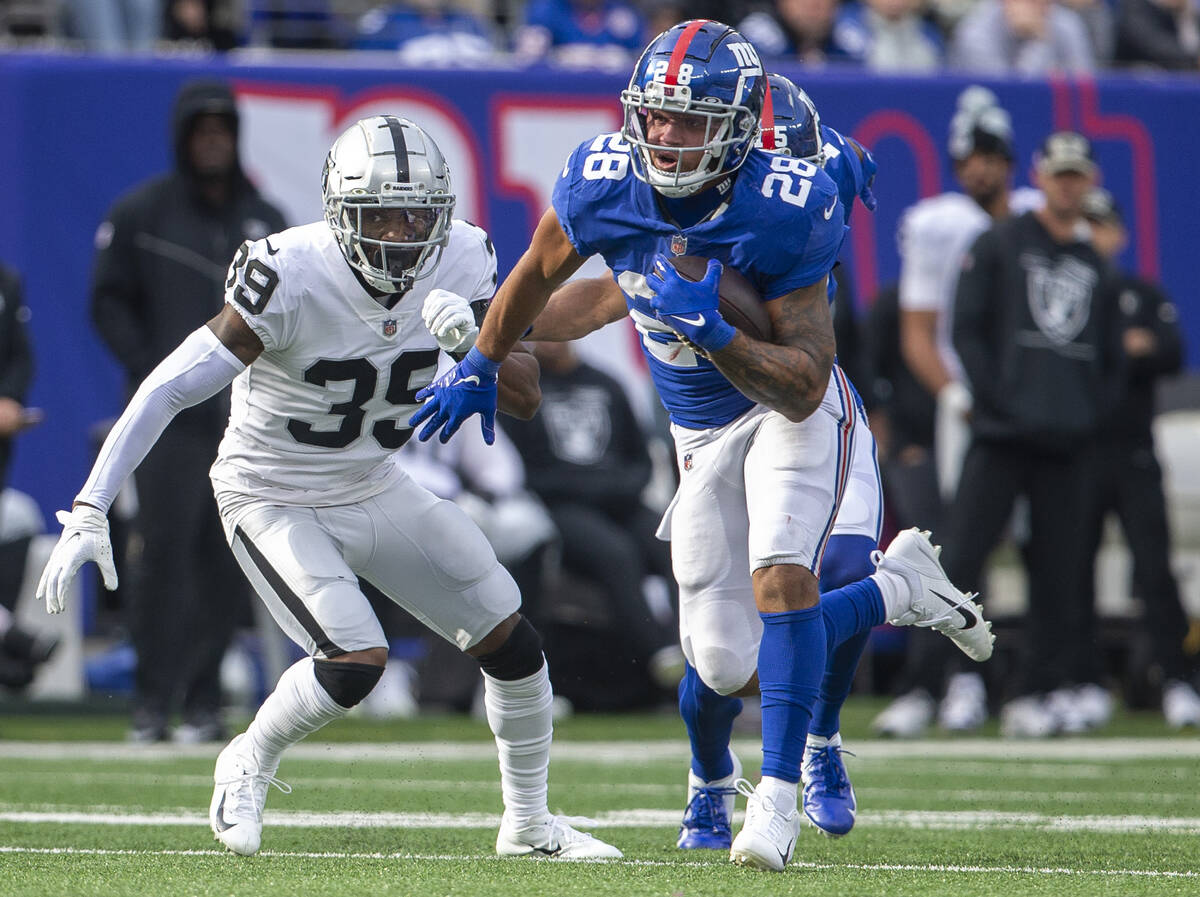 New York Giants running back Devontae Booker (28) runs past Las Vegas Raiders cornerback Nate H ...