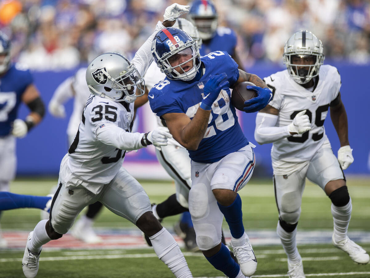 New York Giants running back Devontae Booker (28) breaks through the hole past past Las Vegas R ...