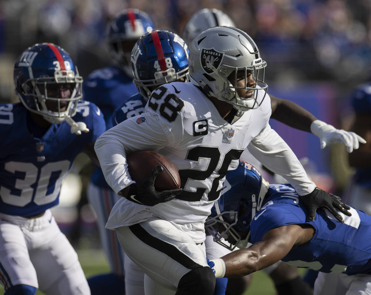 Las Vegas Raiders running back Josh Jacobs (28) rushes past New York Giants cornerback Adoree' ...