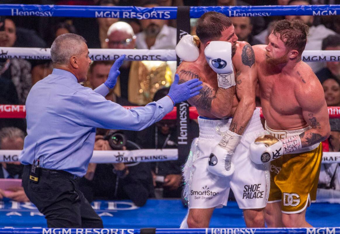 Caleb Plant and Saul "Canelo" Alvarez tie up in the 5th round during their super midd ...