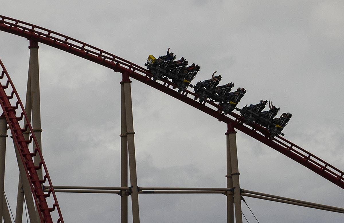 Tourist ride a rollercoaster under a dark sky at New York-New York hotel and casino, on Monday, ...