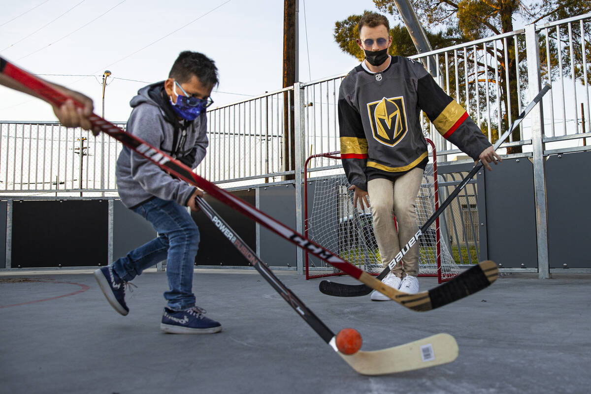 Newly acquired Golden Knights center Jack Eichel, right, defends the net against Alexander, 9, ...