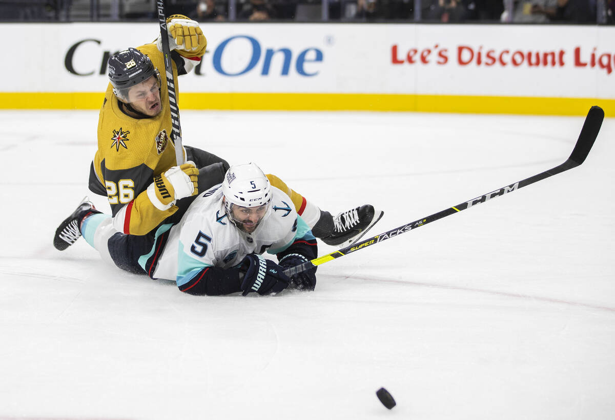 Vegas Golden Knights center Mattias Janmark (26) fights for a loose puck with Seattle Kraken de ...