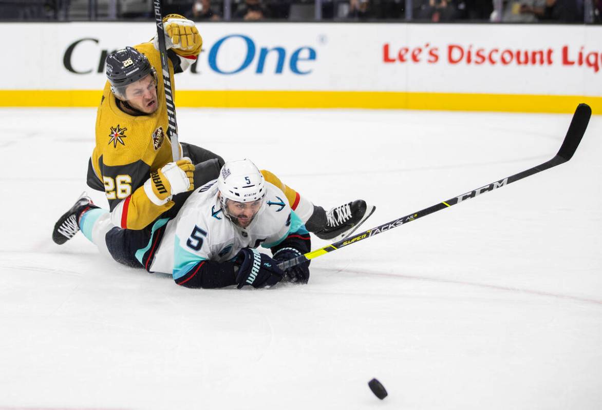 Vegas Golden Knights center Mattias Janmark (26) fights for a loose puck with Seattle Kraken de ...