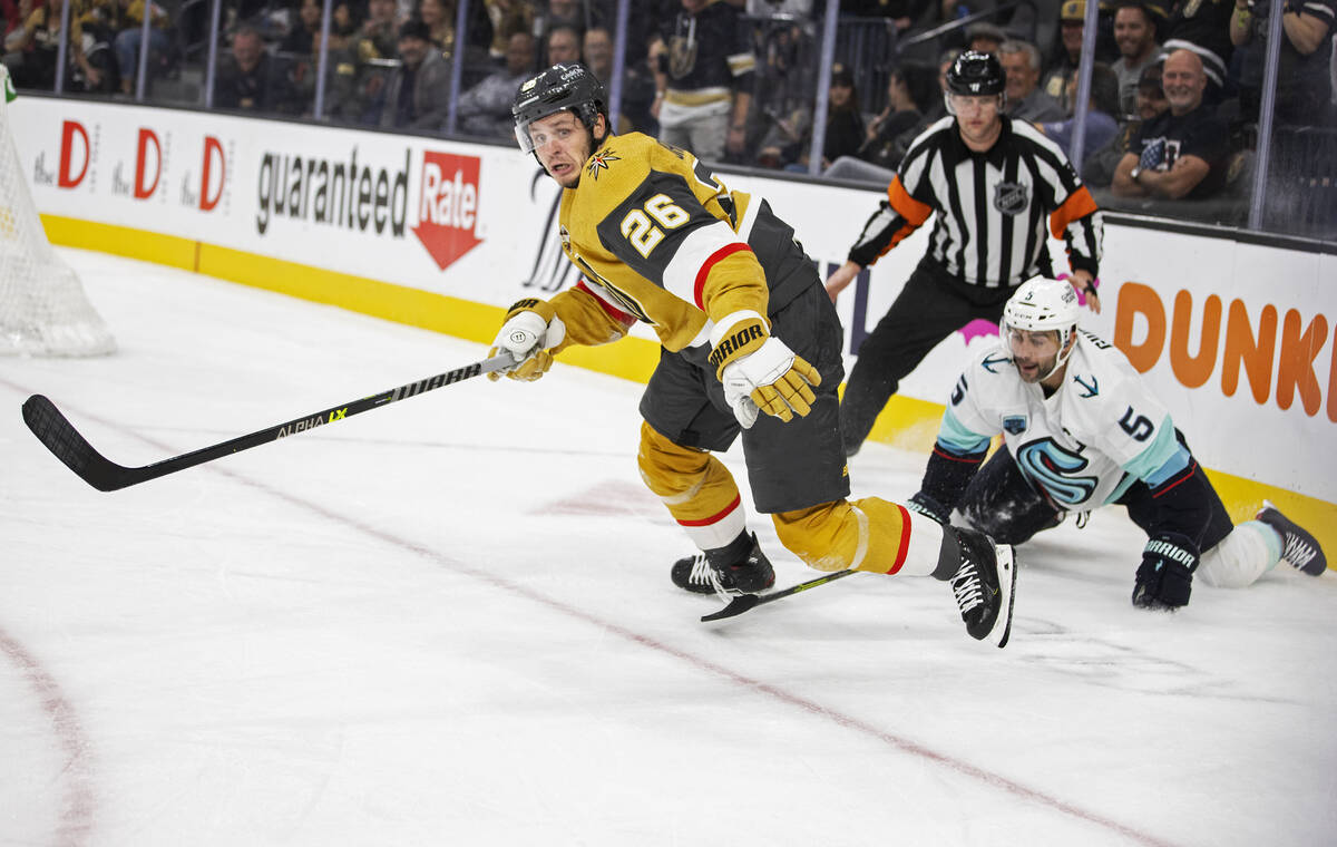 Vegas Golden Knights center Mattias Janmark (26) fights for a loose puck with Seattle Kraken de ...