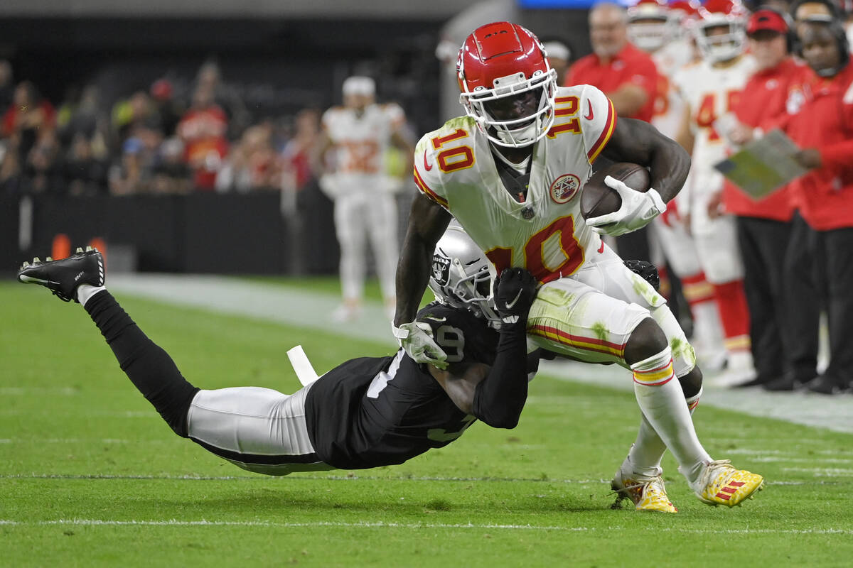 Kansas City Chiefs wide receiver Tyreek Hill (10) breaks a tackle by Las Vegas Raiders cornerba ...