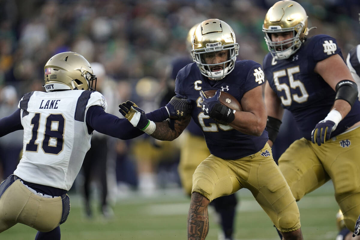 Notre Dame running back Kyren Williams (23) runs past Navy safety Rayuan Lane (18) for a 20-yar ...
