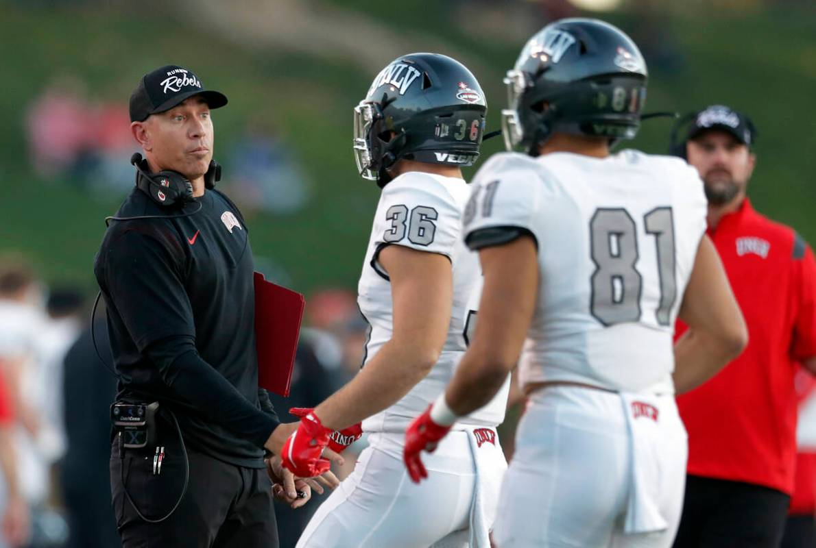UNLV coach Marcus Arroyo, left, talks with running back Chad Magyar (36) during the first half ...