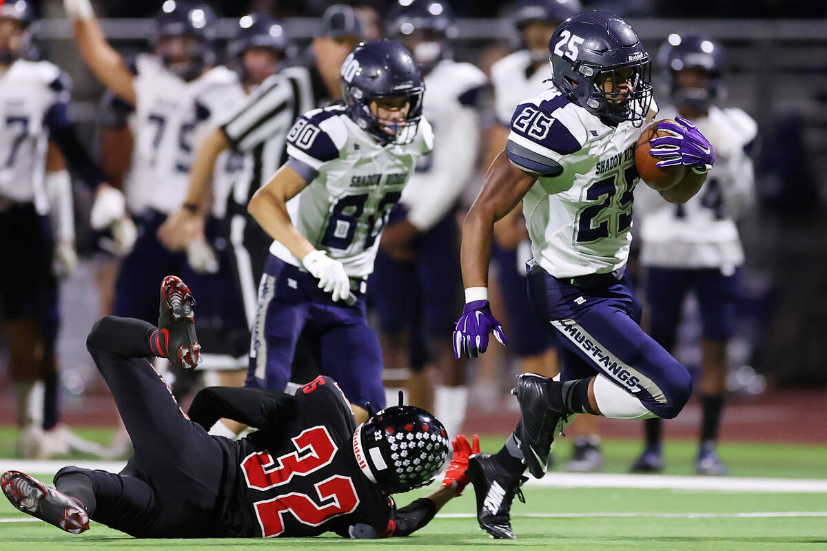 Shadow Ridge's Jaquieze Holland (25) is tripped by Las Vegas' Camden Bradshaw (32) after a run ...