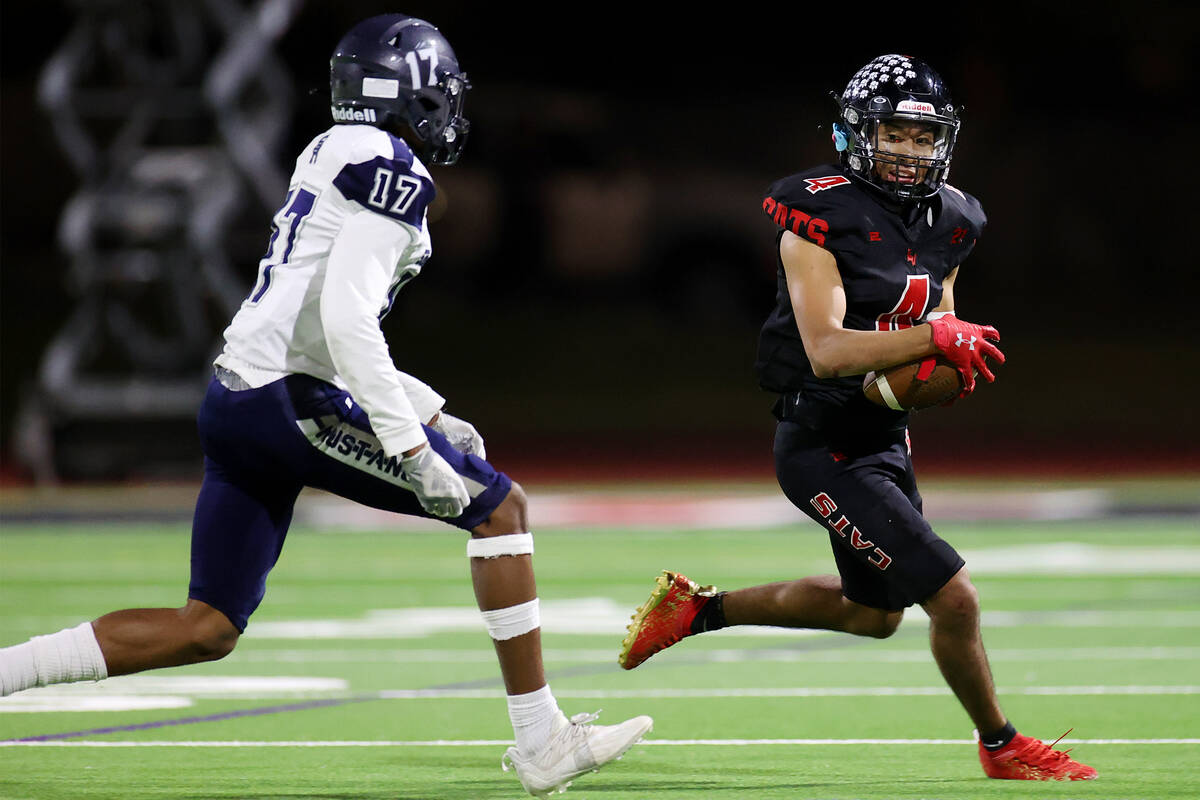 Las Vegas' Alvaro Zentino (4) runs the ball under pressure from Shadow Ridge's Bryson Wilson (1 ...