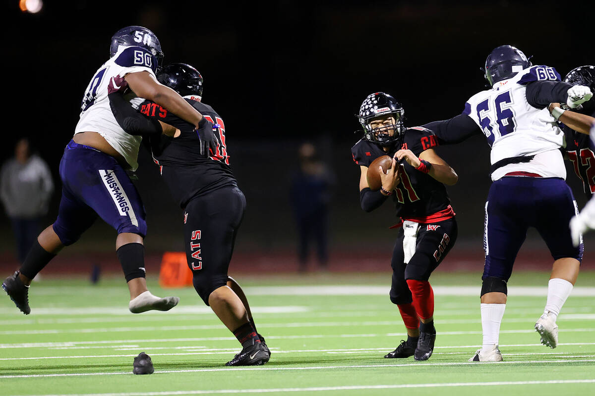 Las Vegas' quarterback Elijah Espinoza (11) is pressure by Shadow Ridge's Nathan Smith (56) in ...