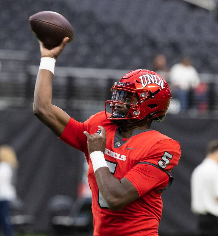 Rebels quarterback Justin Rogers (5) throws the ball as he warms up before an NCAA football gam ...