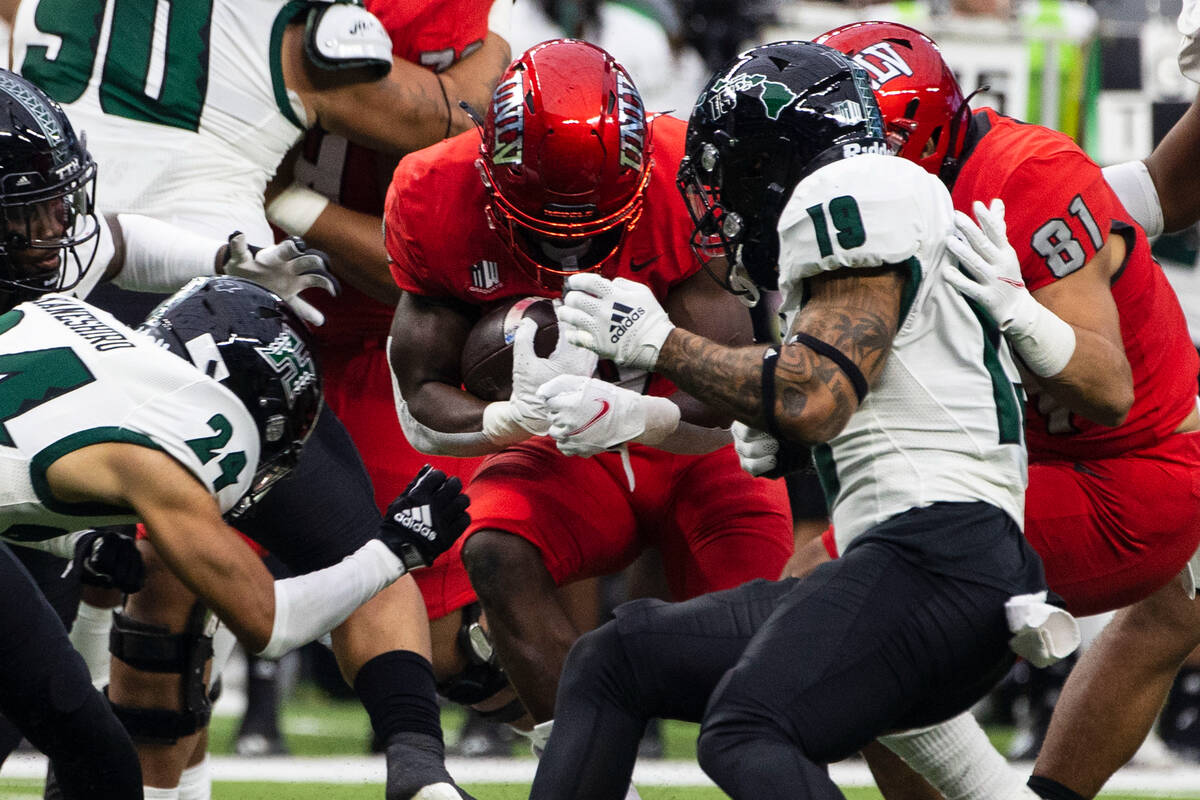UNLV Rebels running back Charles Williams (8) tries to runs with the ball as Hawaii Warriors de ...