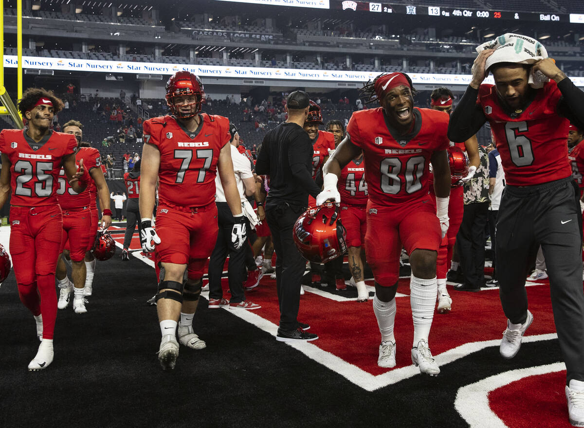 UNLV Rebels players celebrate after beating Hawaii Warriors during an NCAA football game at Al ...