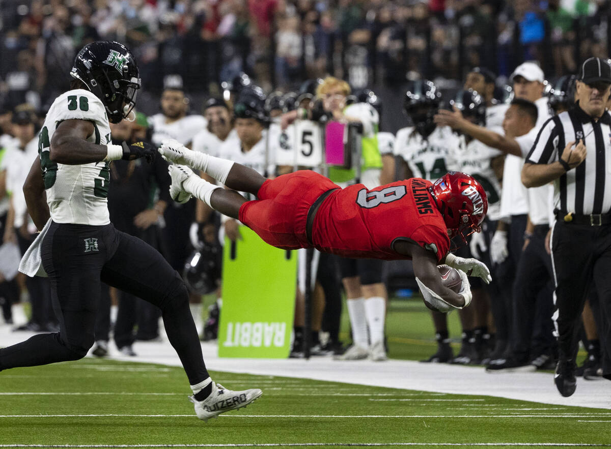 UNLV Rebels running back Charles Williams (8) dives to gain extra yards as Hawaii Warriors defe ...