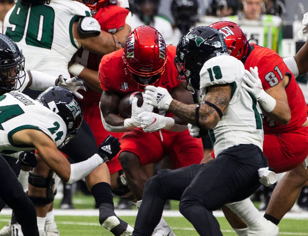 UNLV Rebels running back Charles Williams (8) tries to runs with the ball as Hawaii Warriors de ...