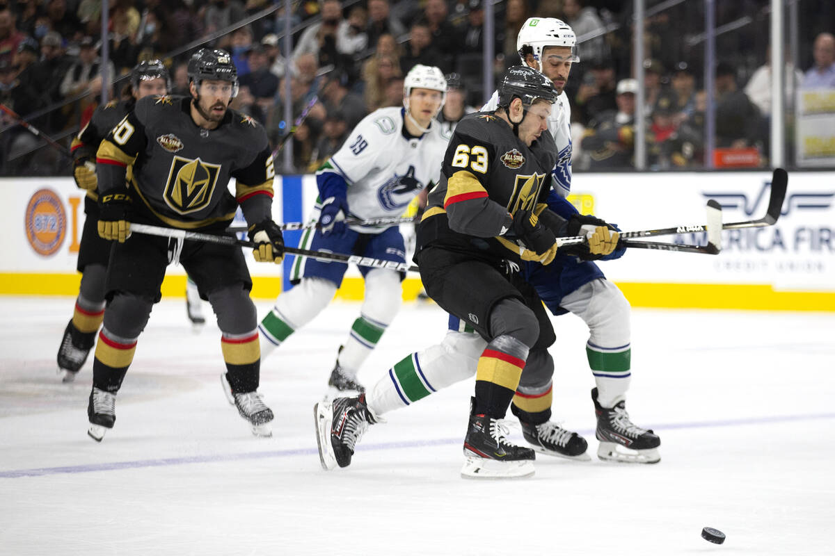 Golden Knights right wing Evgenii Dadonov (63) collides with Canucks right wing Justin Bailey ( ...