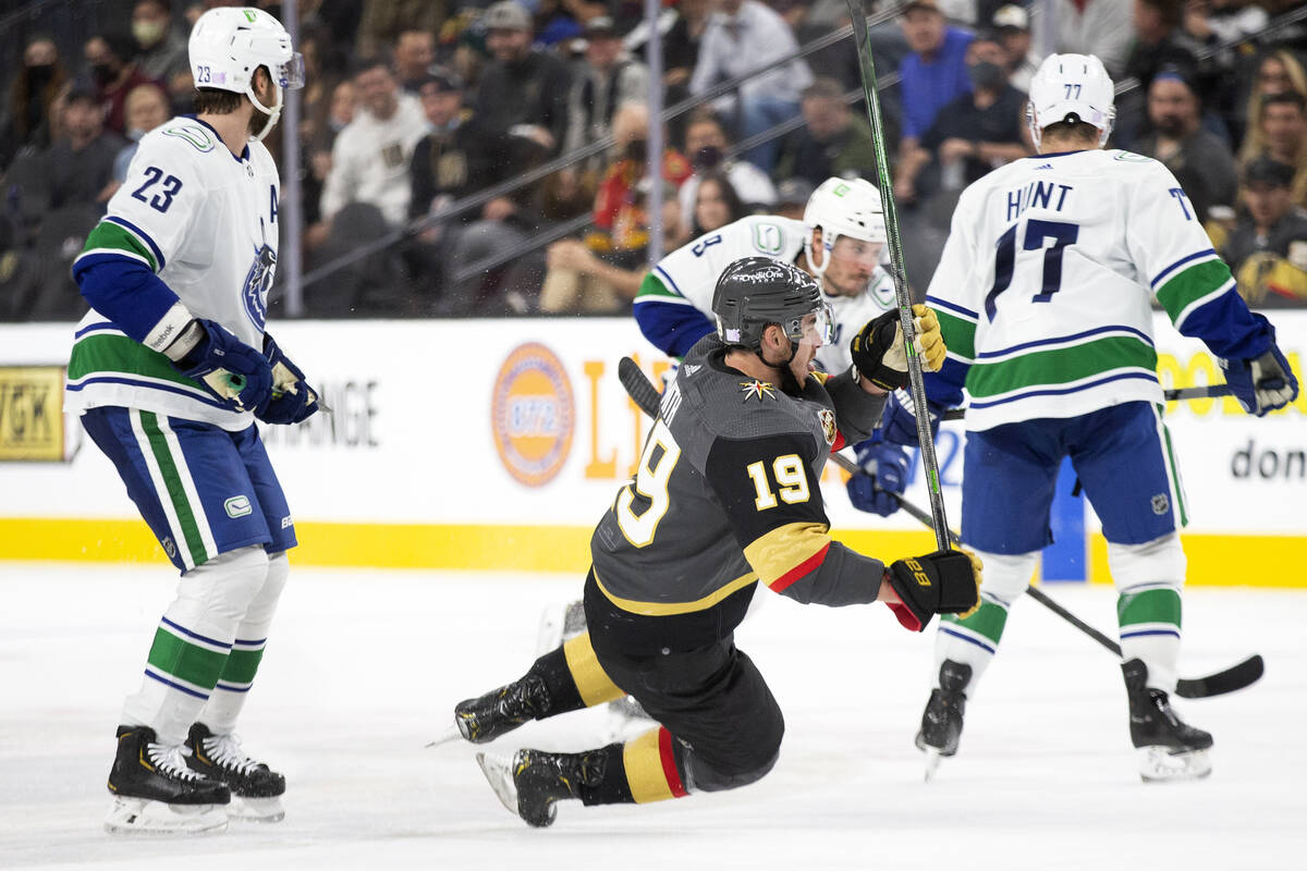 Canucks defenseman Jack Rathbone (3) knocks down Golden Knights right wing Reilly Smith (19) wh ...