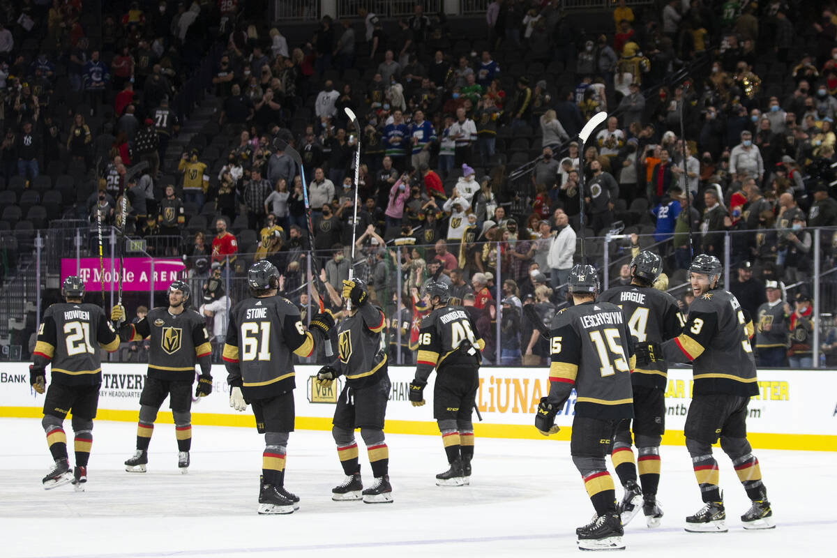 The Golden Knights throw their sticks up after defeating the Canucks 7-4 in a NHL hockey game o ...