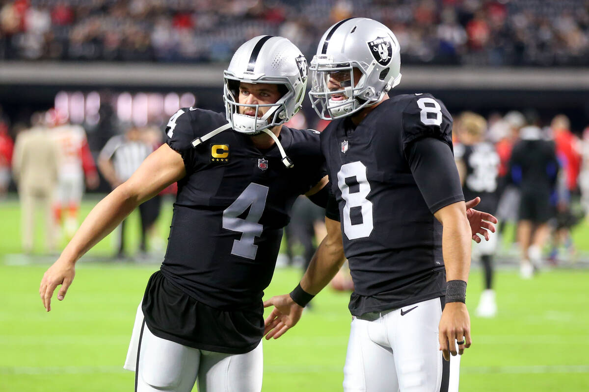 Raiders quarterback Derek Carr (4) and quarterback Marcus Mariota (8) talk before the start of ...