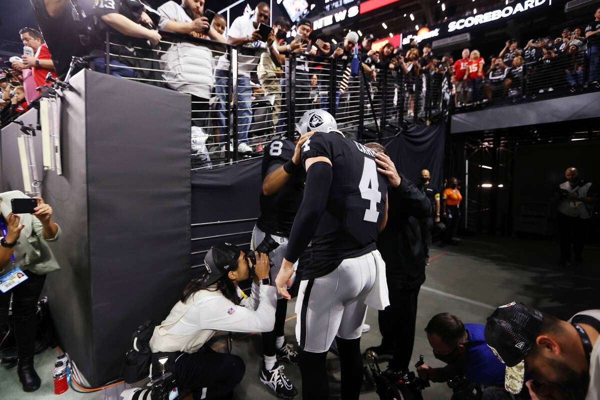 Raiders quarterback Derek Carr (4) and quarterback Marcus Mariota (8) prepare before the start ...