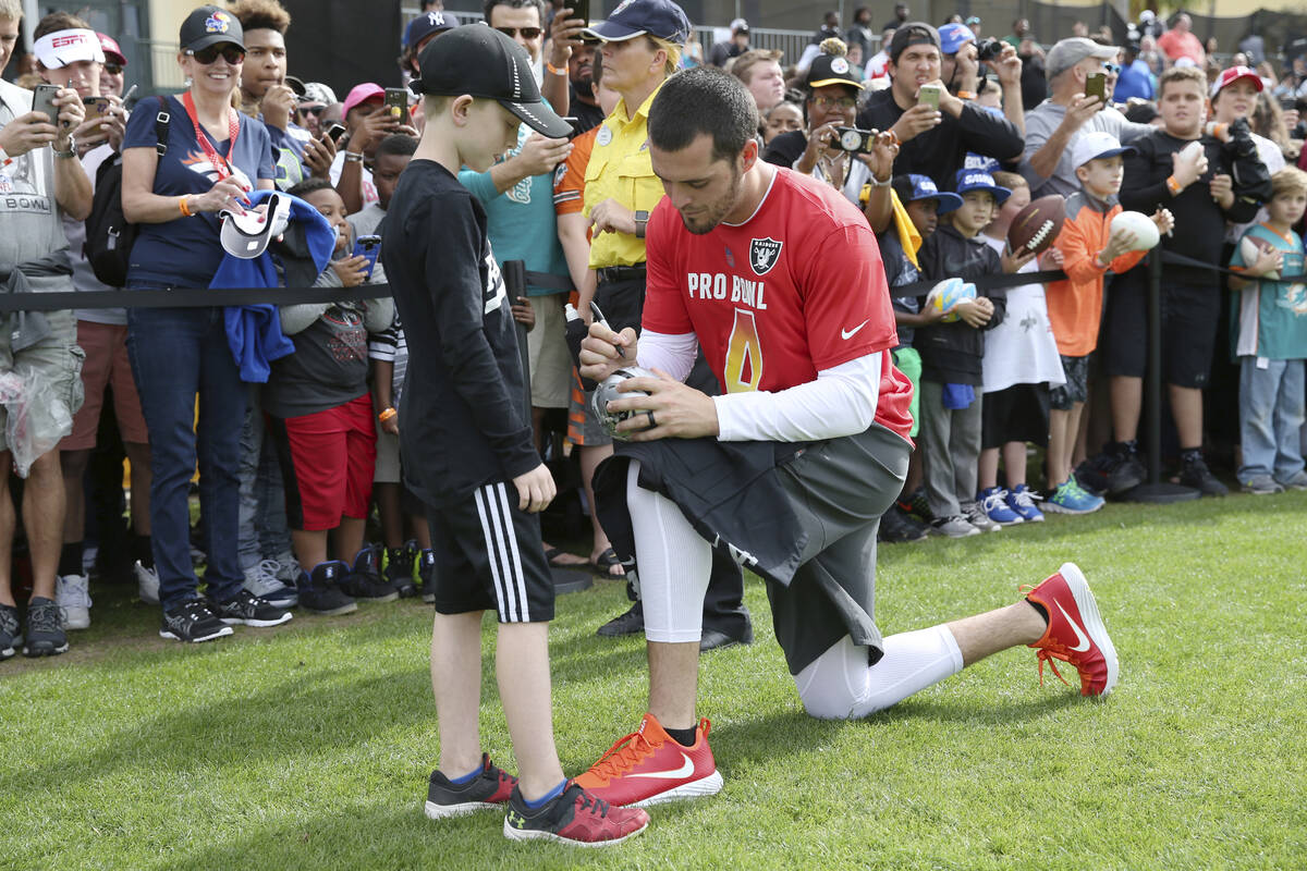 AFC quarterback Derek Carr, of the Oakland Raiders, signs an autograph after Pro Bowl NFL footb ...