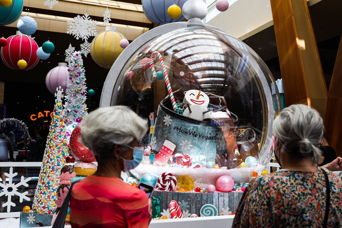 Guests admire the holiday display made of mostly candy created by the Aria’s pastry team ...