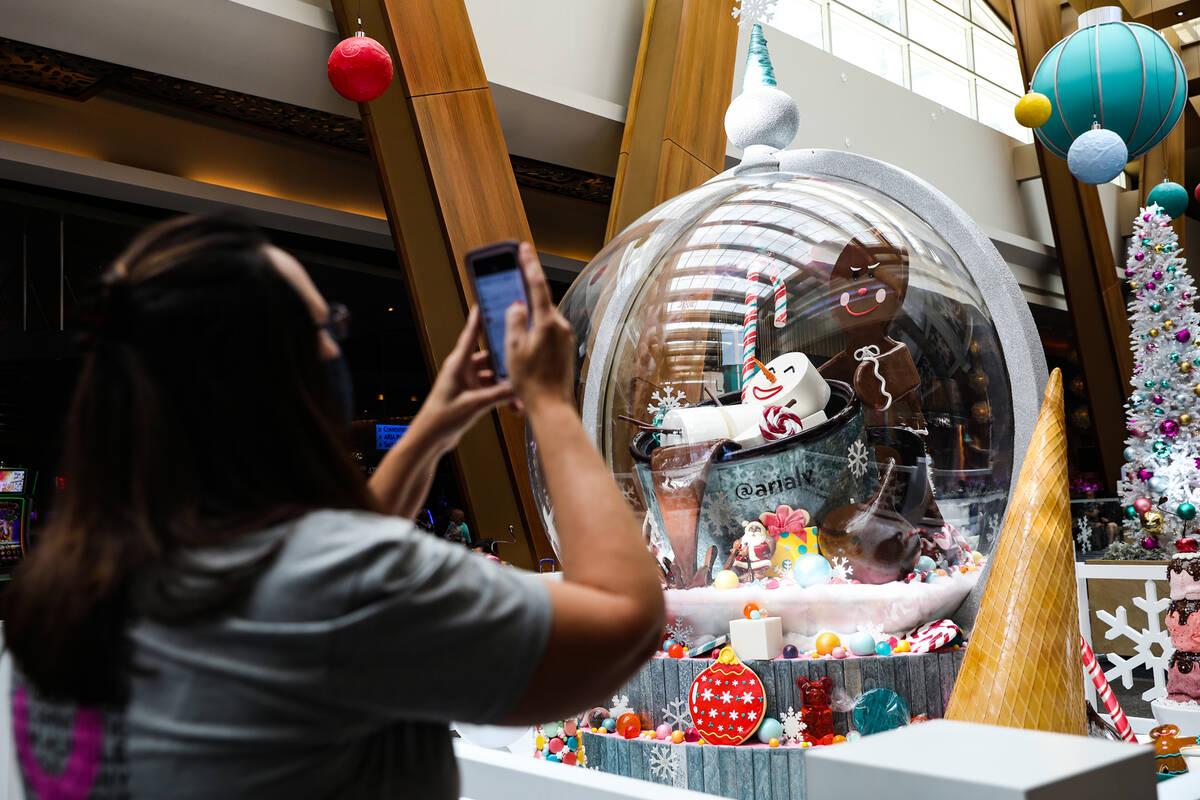 Jennifer Gwinn, of Orlando, takes a photo of the holiday display made of mostly candy created b ...