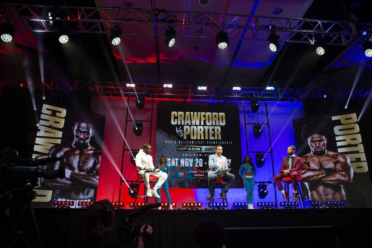 Boxers Terence Crawford, left, and Shawn Porter, right, with moderator Joe Tessitore, during ...