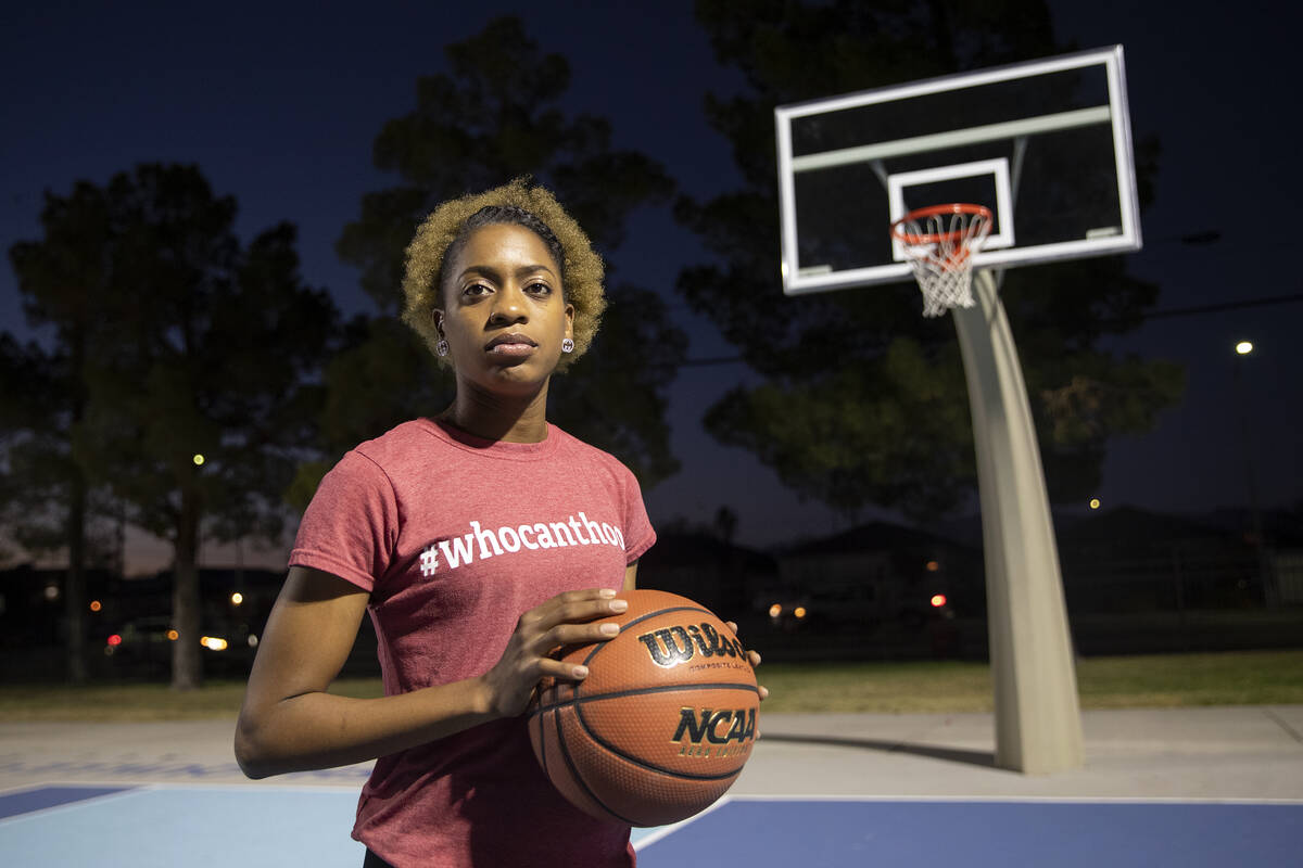 Rayven Thomas, who survived being shot by her ex-boyfriend four months ago, stands at the baske ...