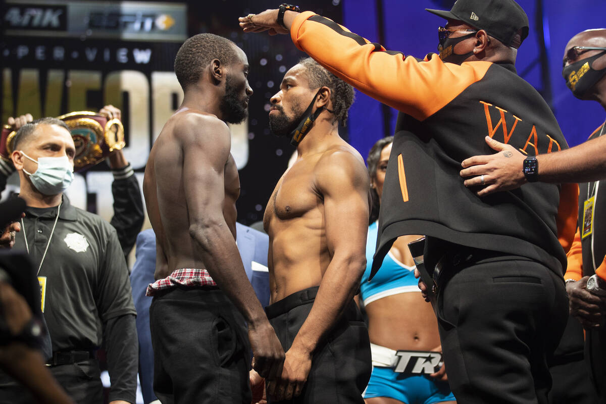 Terence Crawford, left, and Shawn Porter, center, with his father Kenny Porter, pose during a w ...