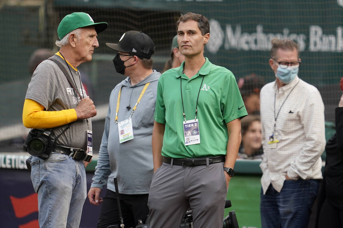 Oakland Athletics President Dave Kaval, center, talks with photographer Michael Zagaris, left, ...