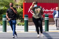 Pedestrians try to keep their balance as they walk against strong winds at the corner of Las Ve ...