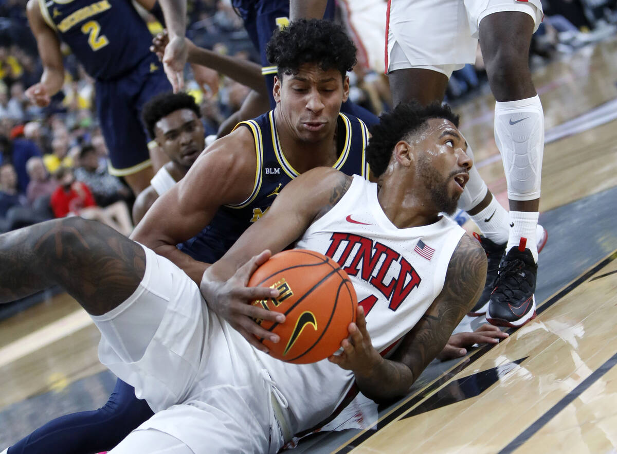UNLV Rebels forward Royce Hamm Jr. (14), foreground, keeps a ball away from Michigan Wolverines ...