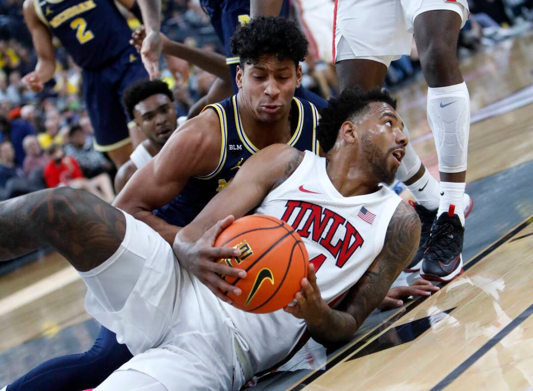 UNLV Rebels forward Royce Hamm Jr. (14), foreground, keeps a ball away from Michigan Wolverines ...