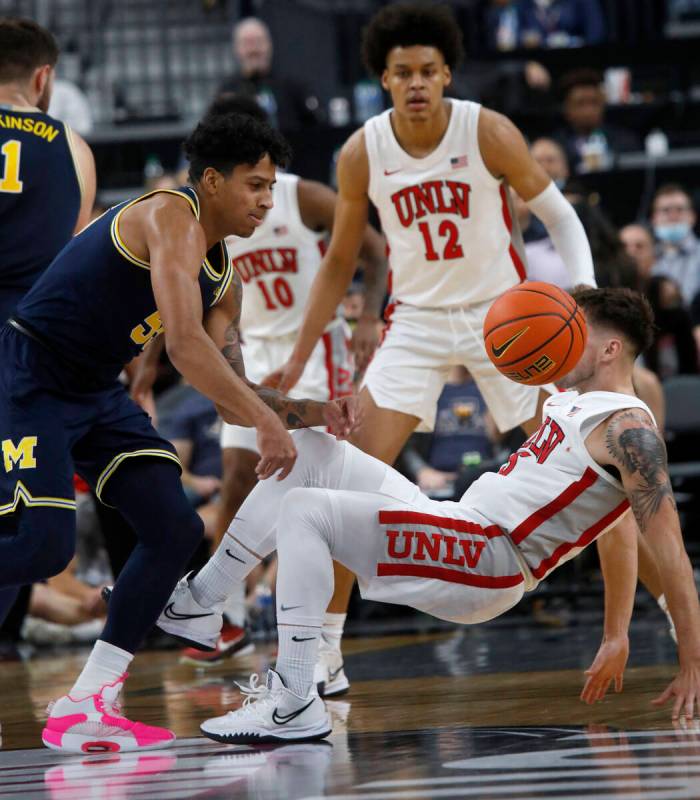 UNLV Rebels guard Jordan McCabe (5) falls to the floor after bumping into Michigan Wolverines g ...