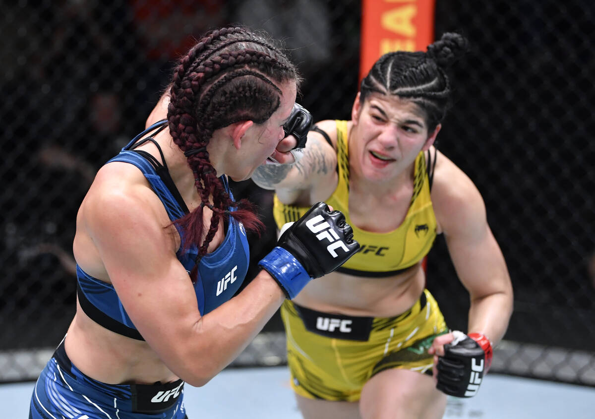 (R-L) Ketlen Vieira of Brazil punches Miesha Tate in a bantamweight fight during the UFC Fight ...