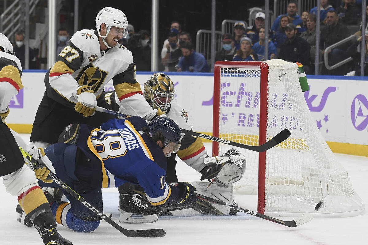 St. Louis Blues' Robert Thomas (18) and Vegas Golden Knights' Shea Theodore (27) vie for the pu ...