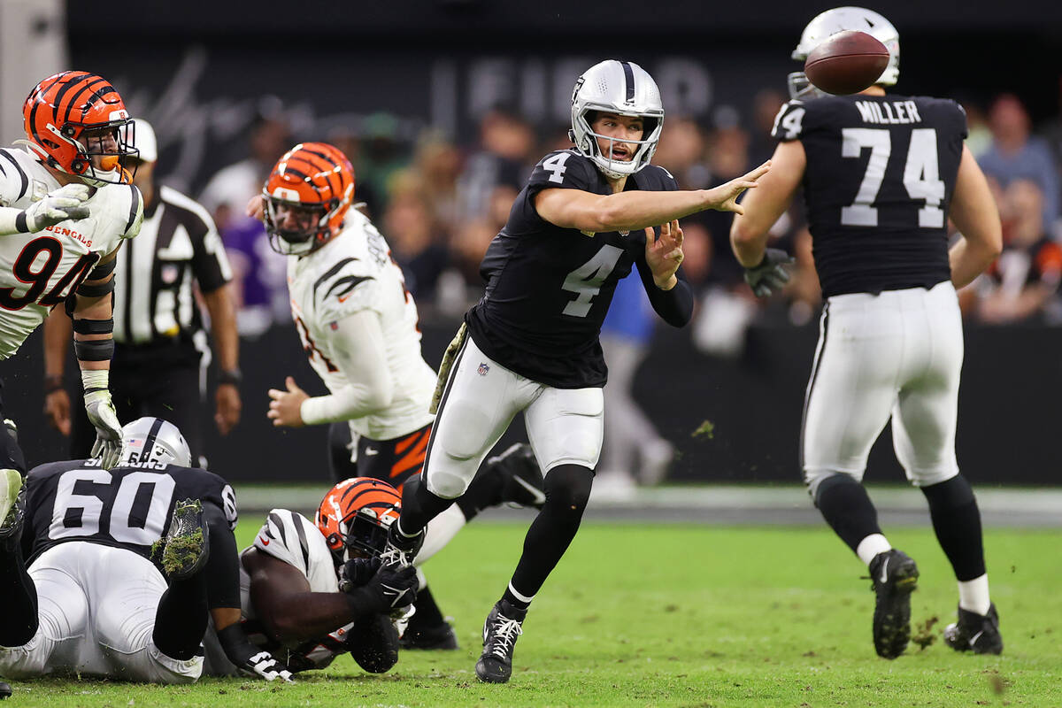 Raiders quarterback Derek Carr (4) makes a pass under pressure from Cincinnati Bengals defensiv ...