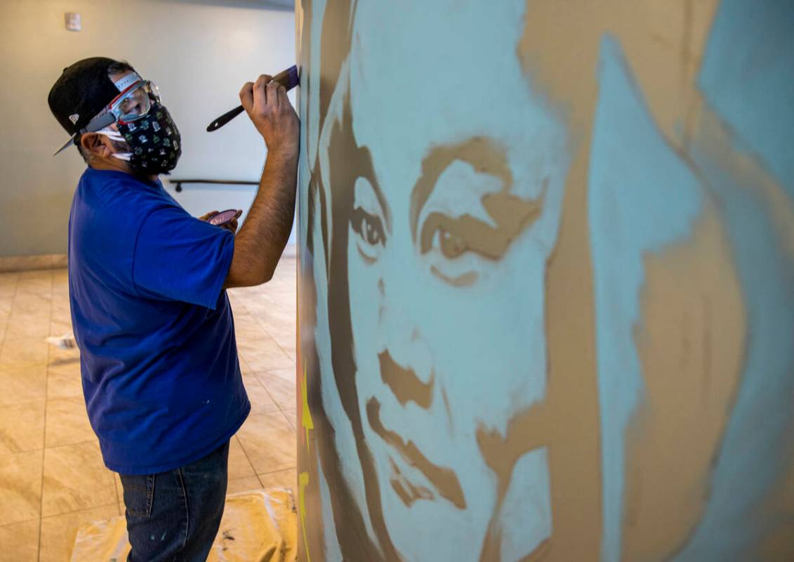 Artist Miguel Hernandez paints a mural in memory of Tony Hsieh in the lobby of ART HOUZ Theater ...