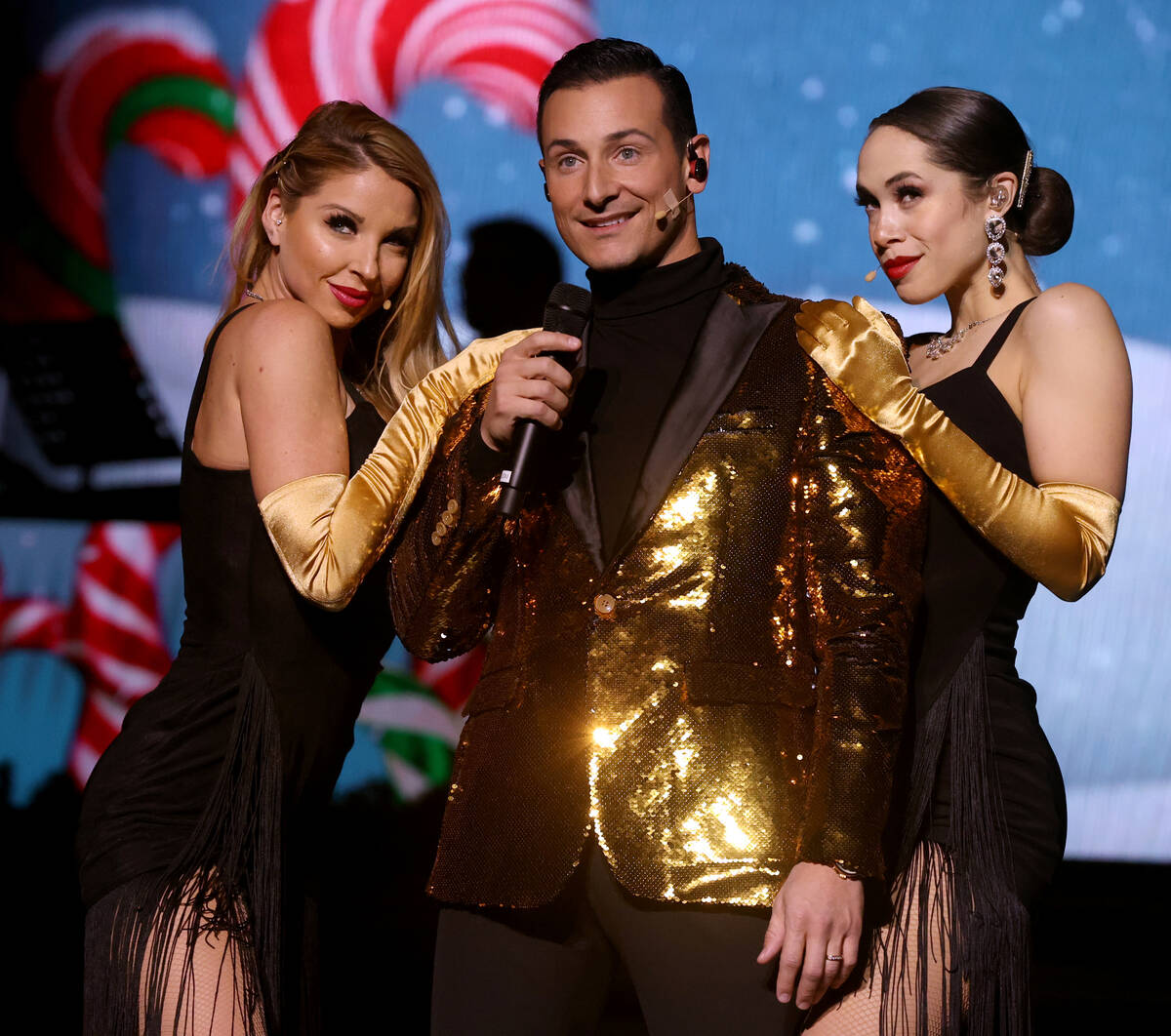 Lou Gazzarra sings "Santa's Back in Town" with Sarah LeClear, left, and Jaclyn McSpad ...