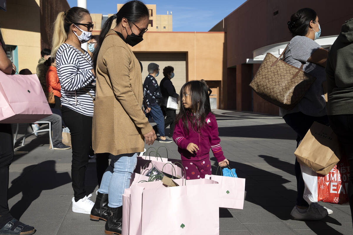 Charrisse Lao, left, Mia Ravelin, cand Giya Lao, 3, carry their haul from Kate Spade while wait ...