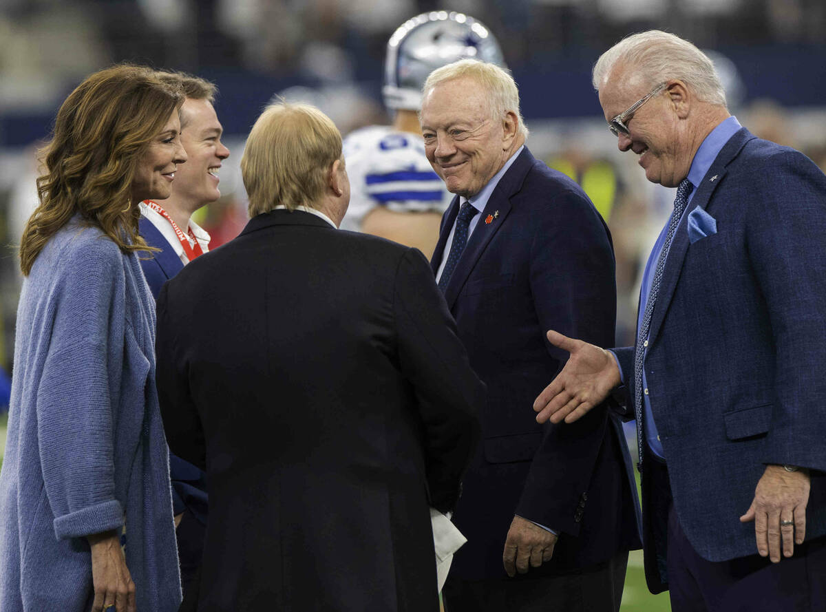 Raiders owner Mark Davis, left/back turned, talks to Cowboys owner Jerry Jones and Executive Vi ...