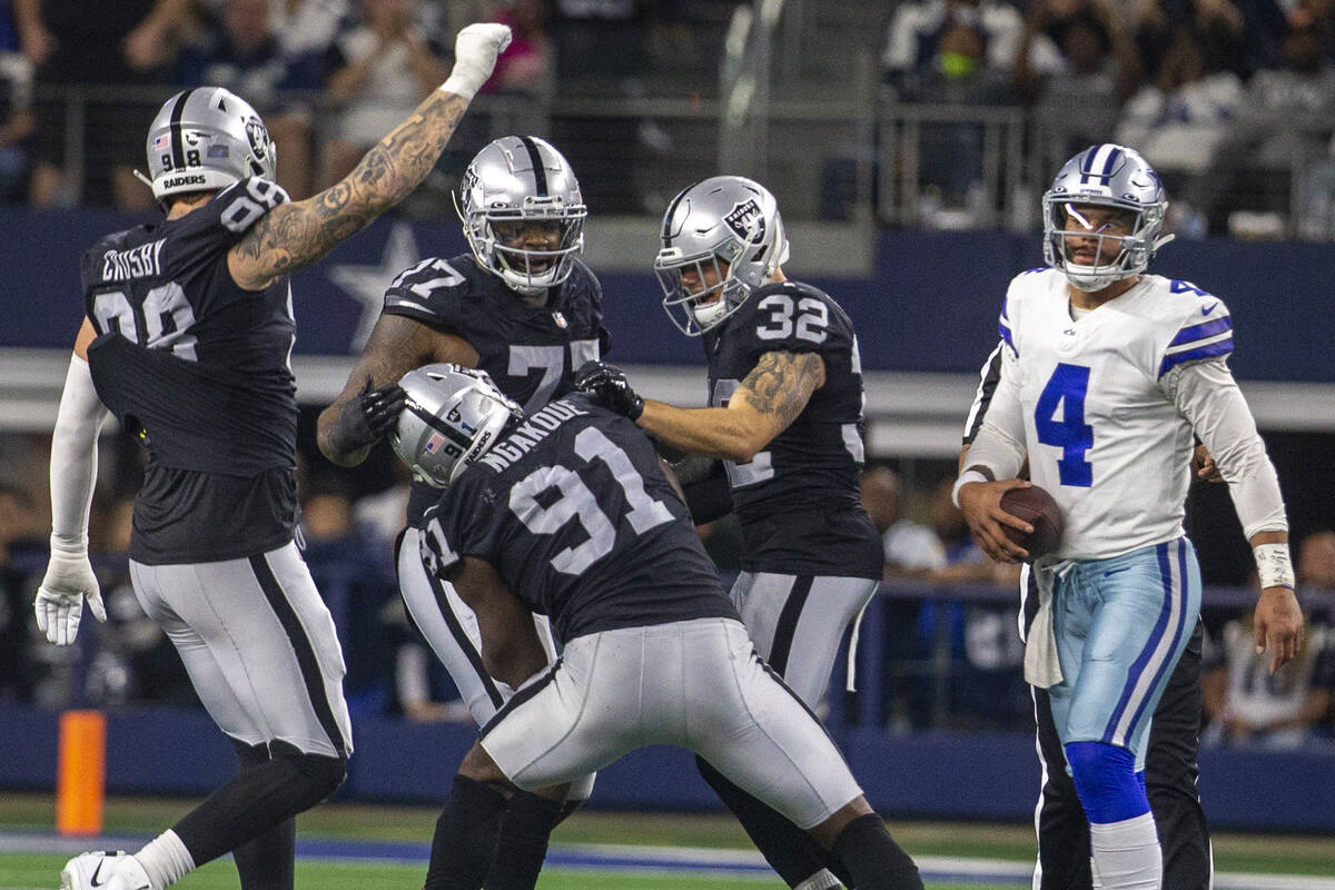 Dallas Cowboys quarterback Dak Prescott (4) walks near as Raiders defensive end Maxx Crosby (98 ...