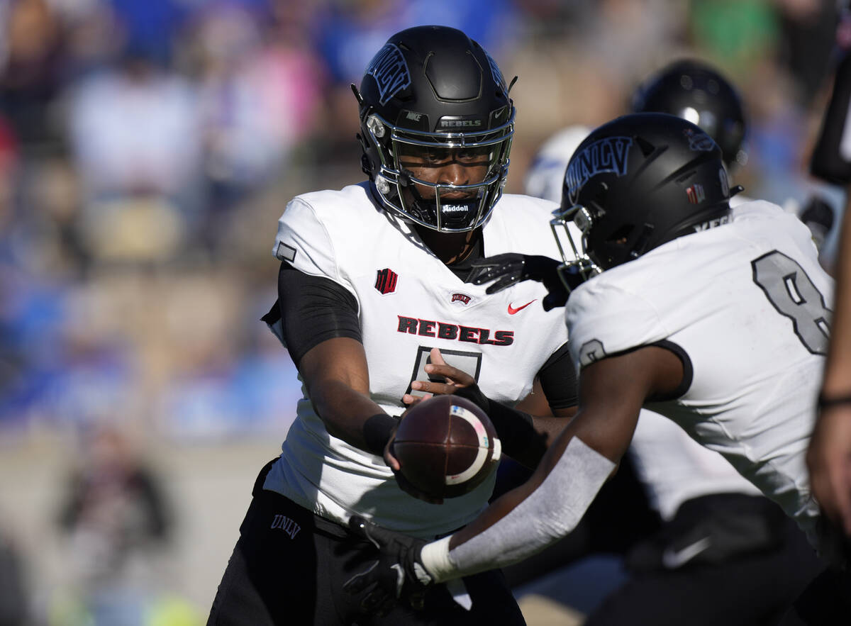 UNLV quarterback Justin Rogers, left, hands off the ball to running back Charles Williams in th ...