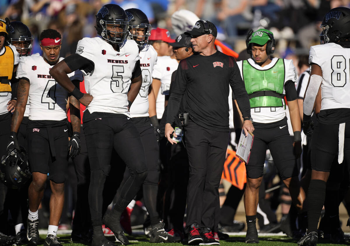 UNLV head coach Marcus Arroyo, right, chats with quarterback Justin Rogers during a time out in ...
