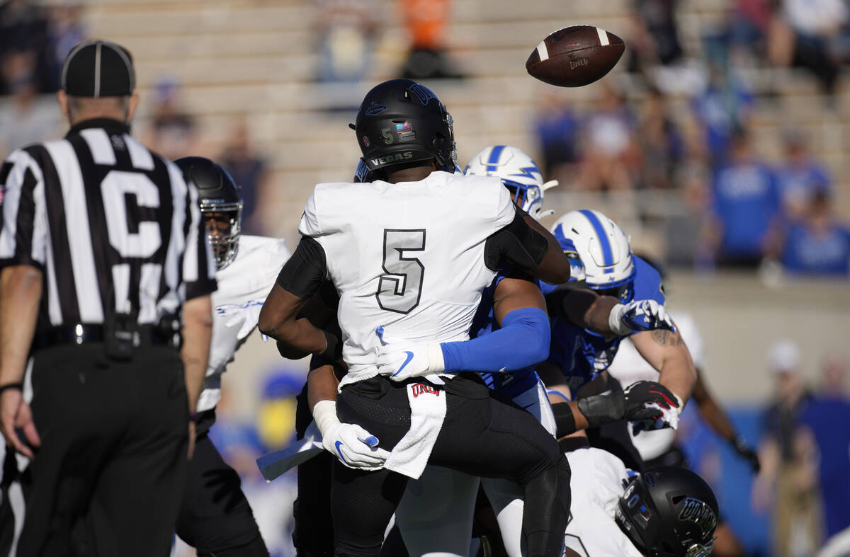 UNLV quarterback Justin Rogers (5) fumbles the ball as he is tackled by Air Force defensive tac ...