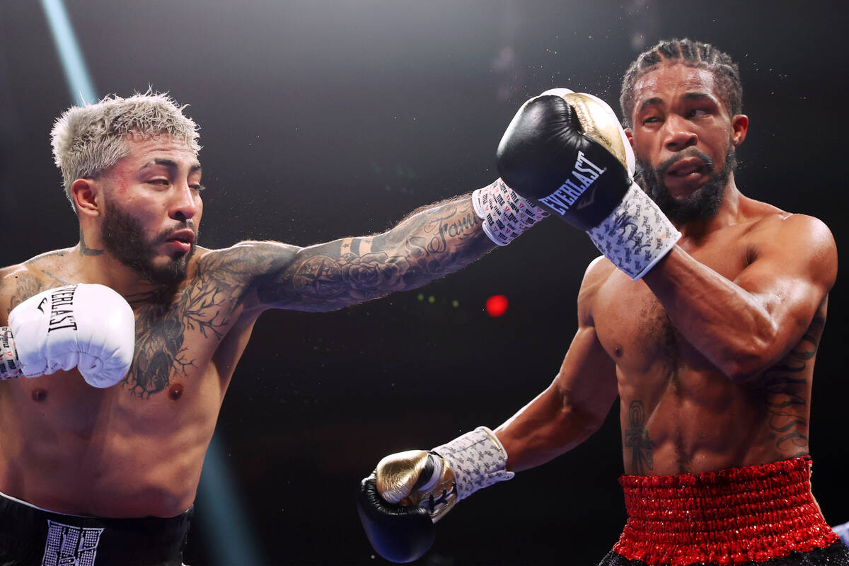 Alexandro Santiago, left, connects a punch against Gary Antonio Russell in the seventh round of ...